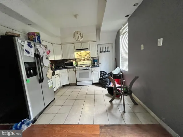 a kitchen with stainless steel appliances kitchen island granite countertop a refrigerator and a sink