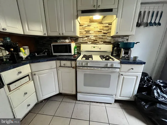 a kitchen with white cabinets and appliances