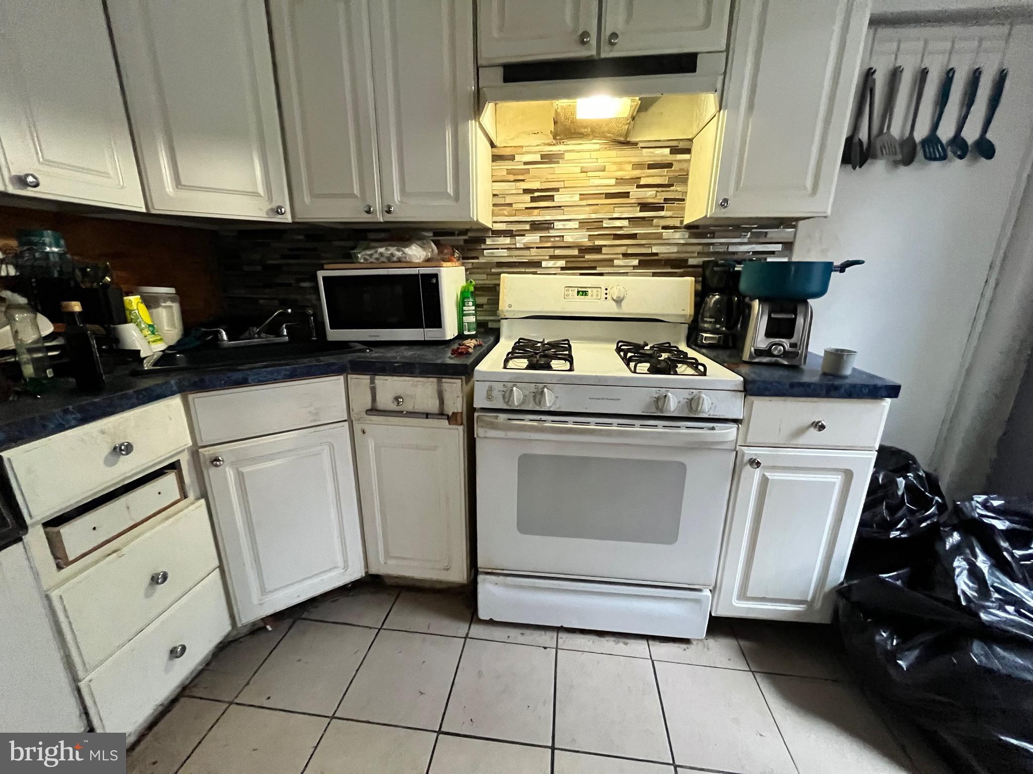 702 Cedar Avenue Lansdowne, PA 19050 - Photo 7 of 9 a kitchen with white cabinets and appliances