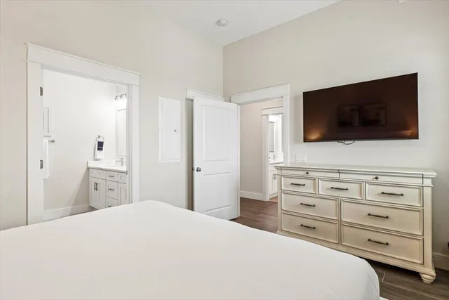 a bedroom with a bed a flat screen tv and dresser