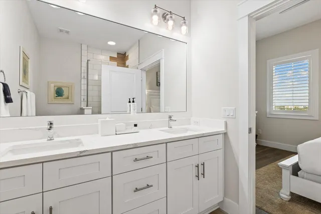 a bathroom with double sink and a mirror