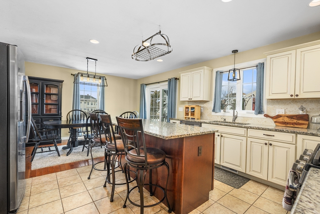 138 Sprague Street Fall River, MA 02724 - Photo 10 of 34 a open kitchen with stainless steel appliances granite countertop table chairs and a refrigerator