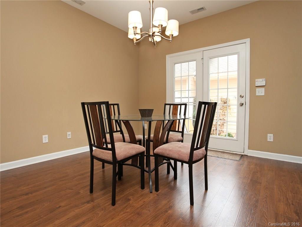 1050 Market Street, Unit 1050 Fort Mill, SC 29708 - Photo 13 of 20 a view of a dining room with furniture a chandelier and wooden floor