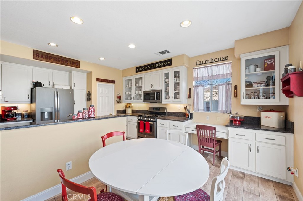 19714 Rotterdam Street Riverside, CA 92508 - Photo 13 of 46 a kitchen with stainless steel appliances kitchen island granite countertop a sink a stove a refrigerator cabinets and a dining table