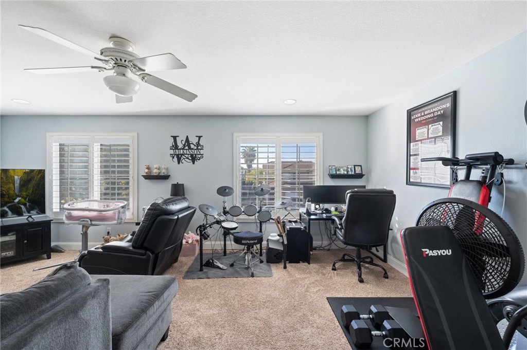 19714 Rotterdam Street Riverside, CA 92508 - Photo 31 of 46 a living room with furniture a fireplace and a flat screen tv