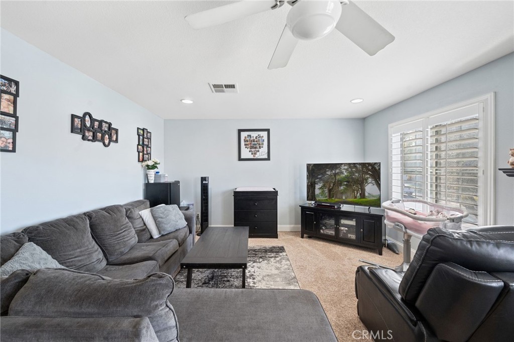19714 Rotterdam Street Riverside, CA 92508 - Photo 32 of 46 a living room with furniture a flat screen tv and a large window