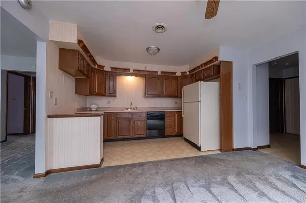 a kitchen with a refrigerator sink and white cabinets