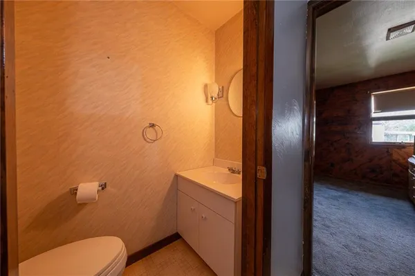 a bathroom with a granite countertop toilet and a sink