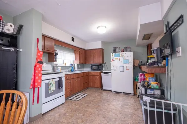 a view of a kitchen with fridge and wooden floor