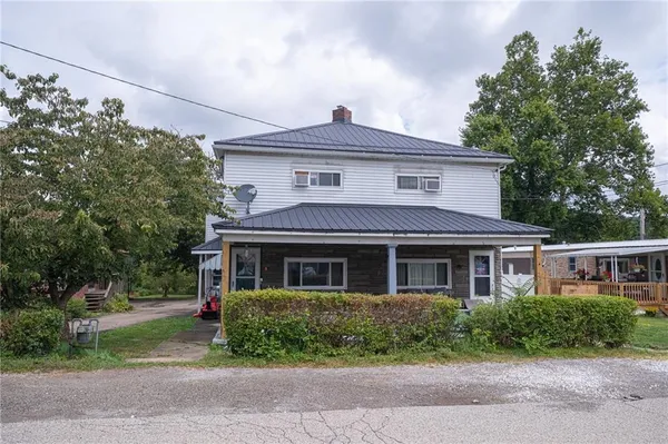 a front view of a house with a yard and potted plants