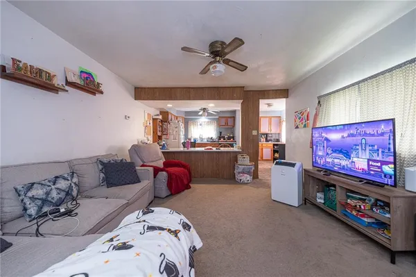 a living room with furniture and a ceiling fan