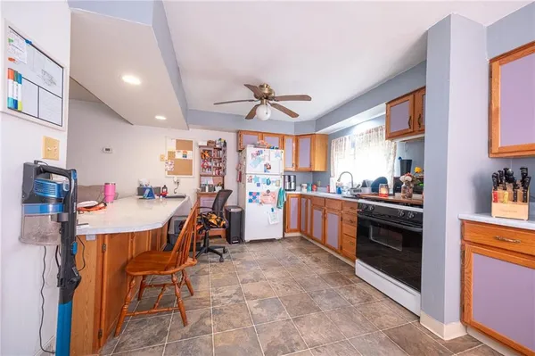 a kitchen with a stove top oven a sink a dining table and chairs