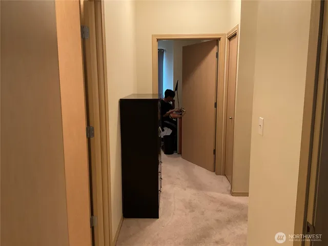a view of a hallway with wooden cabinets