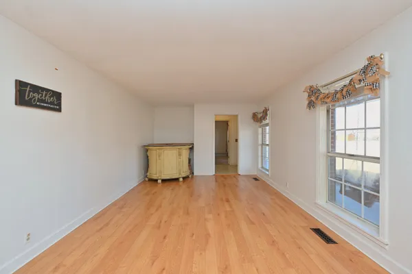 a view of a big room with wooden floor and windows