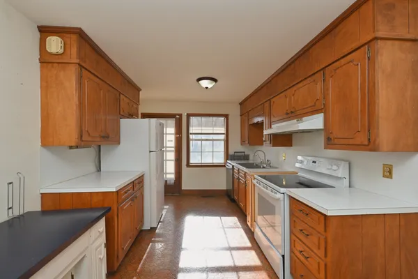 a kitchen with stainless steel appliances a refrigerator a sink a stove and cabinets