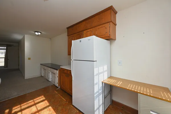 a kitchen with stainless steel appliances granite countertop a refrigerator a sink dishwasher a stove and white countertops with wooden floor