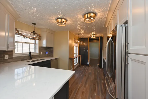 a kitchen with stainless steel appliances granite countertop a stove a sink and a microwave