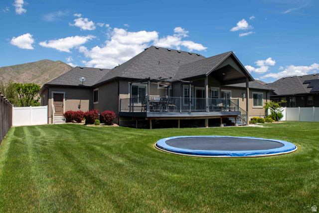 646 East 1400th Street North Mapleton, UT 84664 - Photo 66 of 78 Expansive backyard featuring a manicured lawn, a large elevated deck with a covered patio area, and mature landscaping