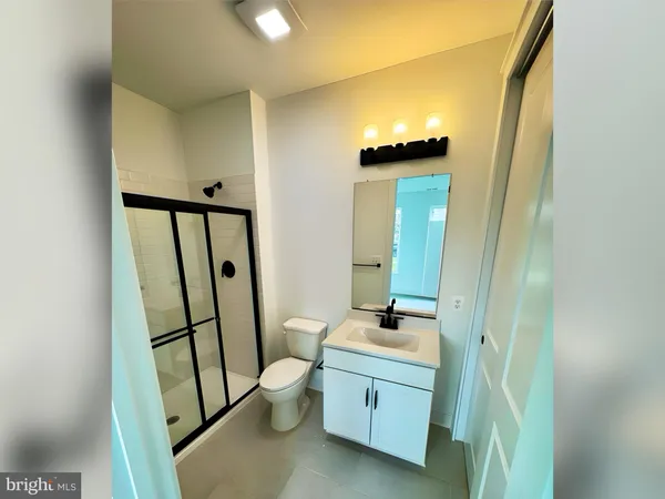 a bathroom with a granite countertop sink toilet and mirror
