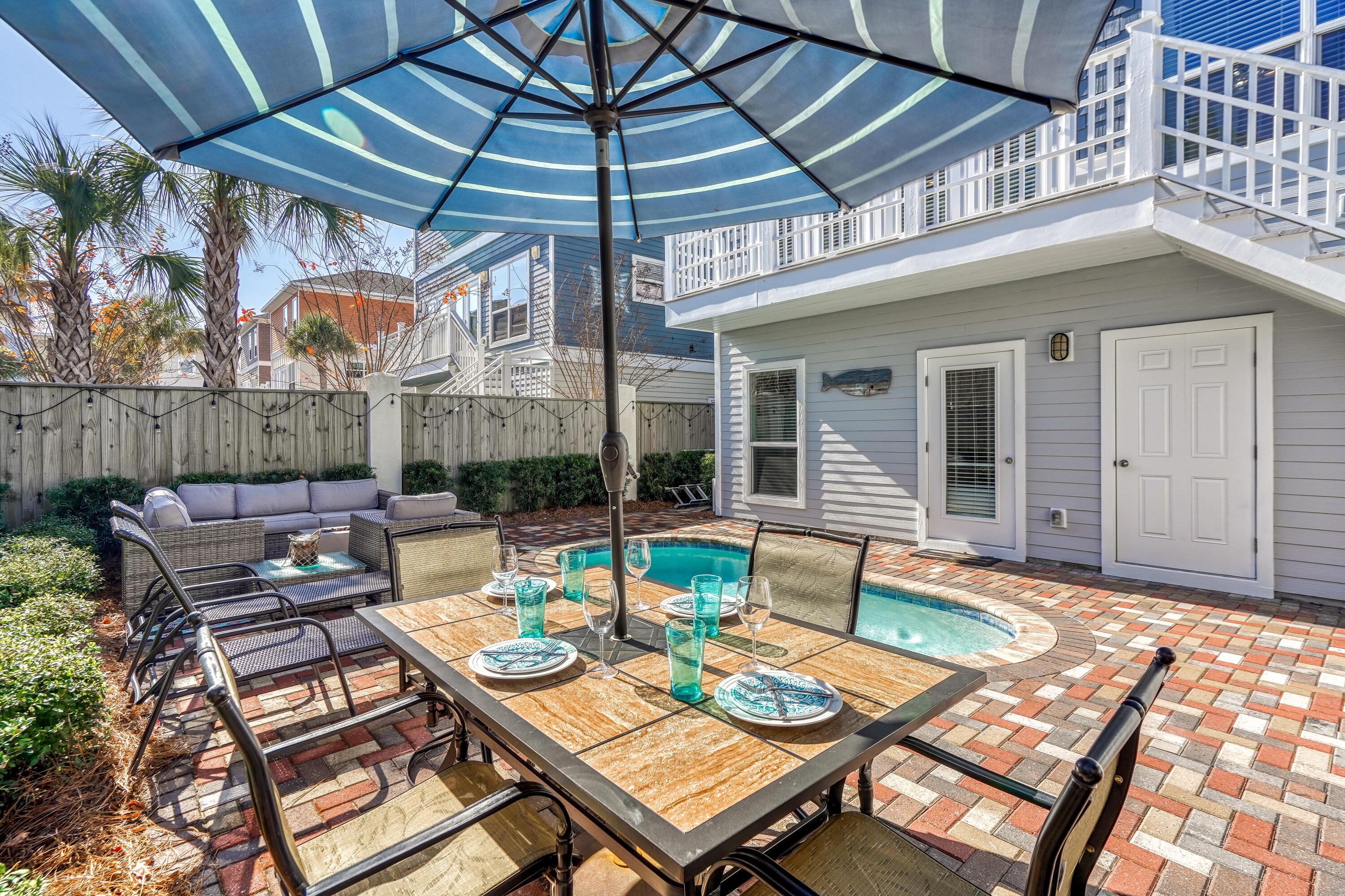 29 Payne Street Miramar Beach, FL 32550 - Photo 42 of 49 a view of a patio with a dining table and chairs under an umbrella