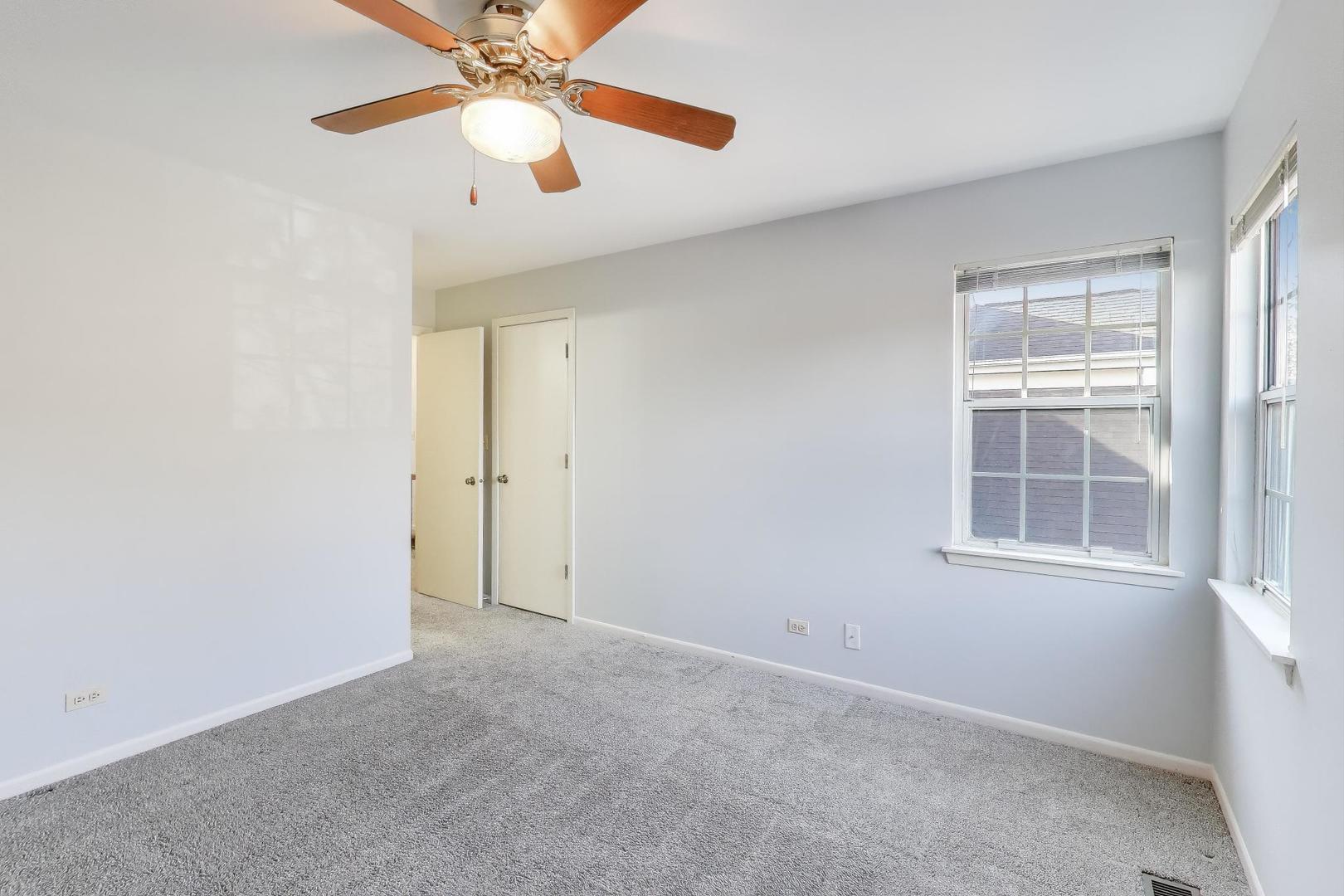 1303 Cranbrook Court Schaumburg, IL 60193 - Photo 15 of 29 an empty room with windows and fan