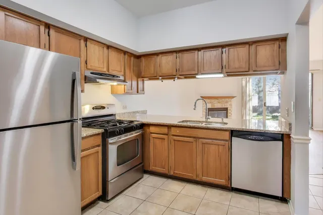 a kitchen with stainless steel appliances granite countertop a refrigerator sink and cabinets