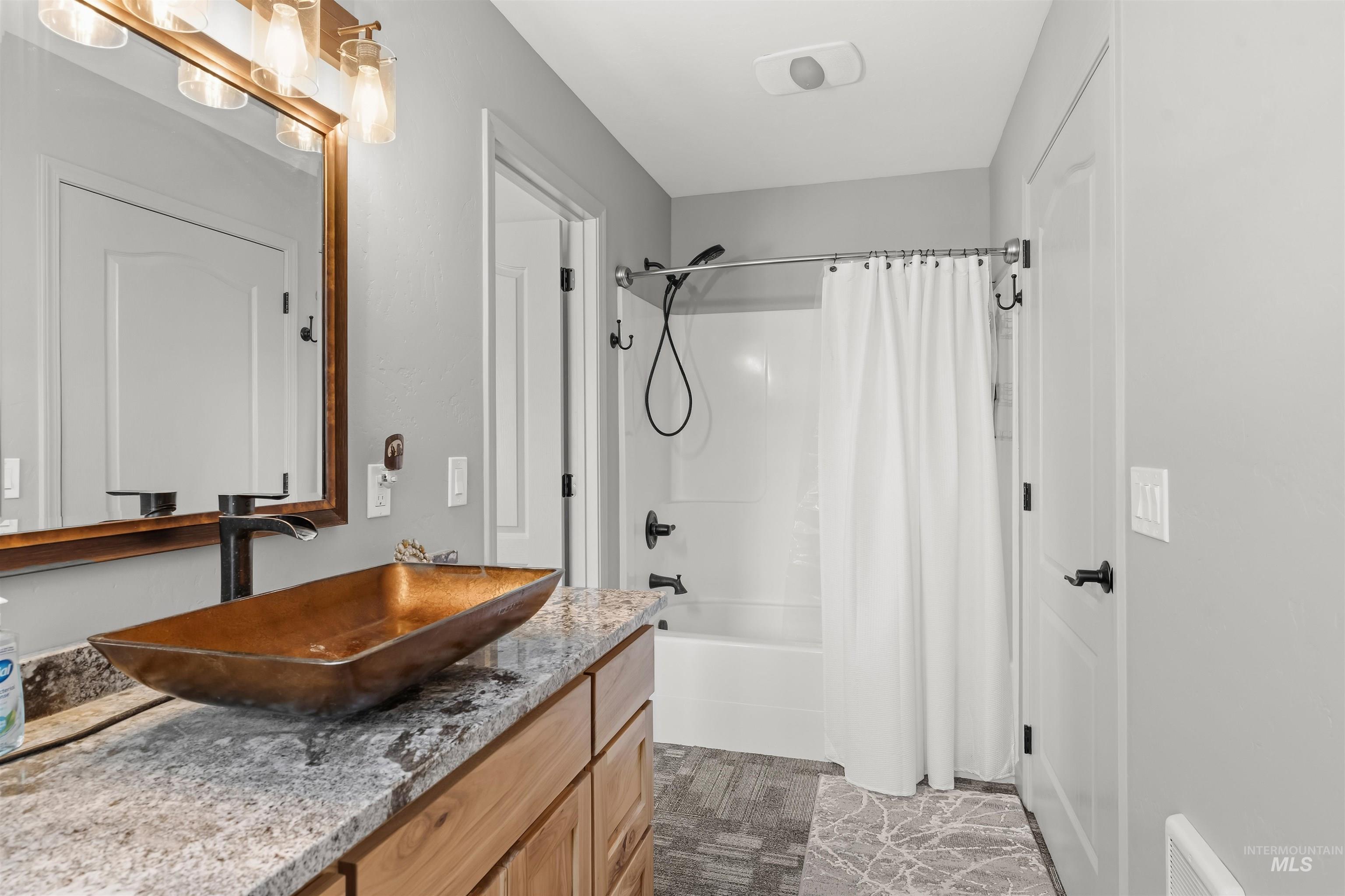 507 Bearlea Road Anatone, WA 99401 - Photo 12 of 47 Bathroom featuring a striking vessel sink, a granite-finish countertop, and wood-finish cabinetry