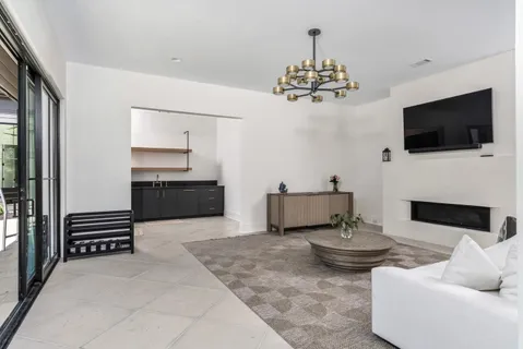 a living room with furniture a flat screen tv and kitchen view
