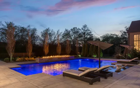 a view of swimming pool with outdoor seating and yard in the back