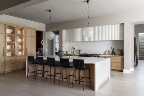a kitchen with cabinets and chairs