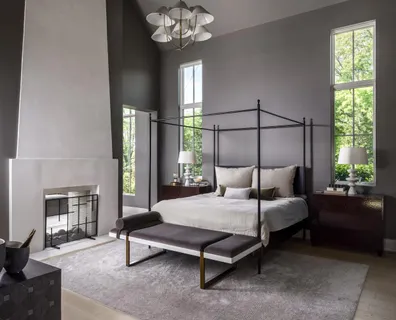 a bedroom with a bed lamp and a fireplace