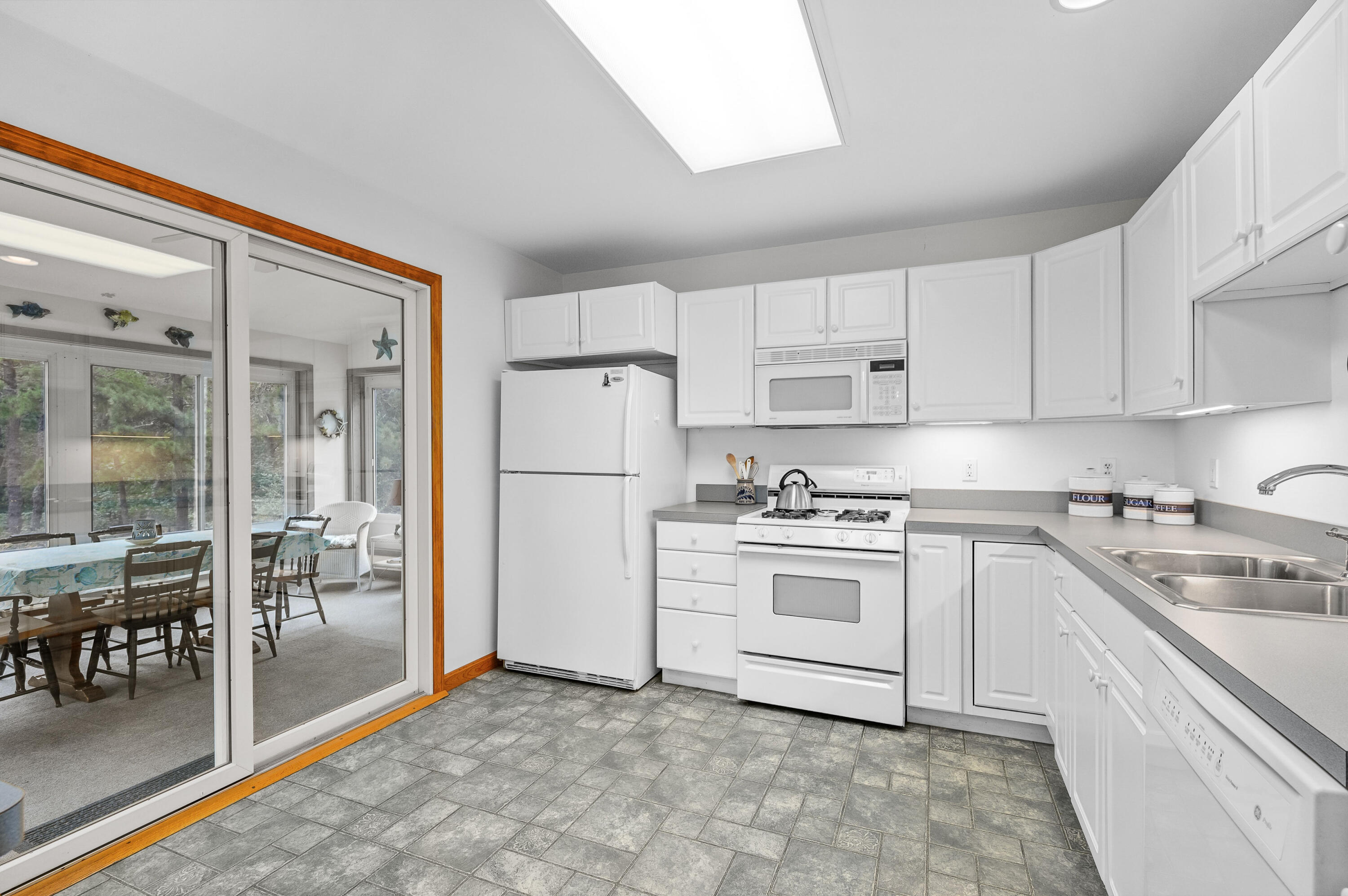86 Old Wharf Road Wellfleet, MA 02667 - Photo 12 of 37 a kitchen with white cabinets and white appliances