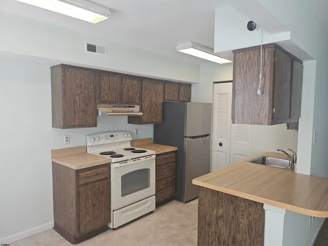 a kitchen with a stove a sink and a refrigerator