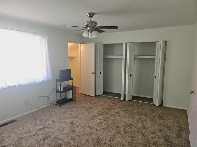 an empty room with windows and closet