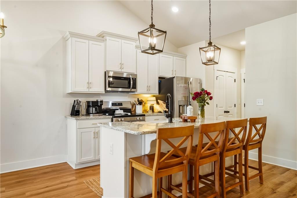3462 Vinson Mountain Road Rockmart, GA 30153 - Photo 11 of 31 a kitchen with stainless steel appliances kitchen island granite countertop a table and chairs in it