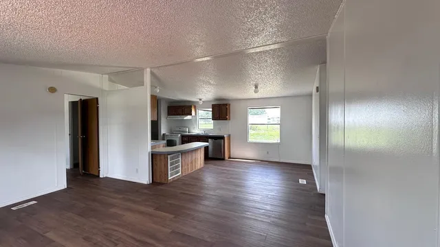 a view of kitchen with sink refrigerator and window