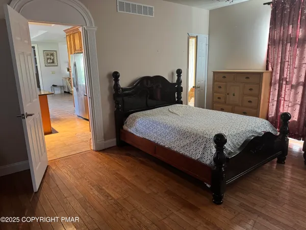a bedroom with a bed and wooden floor