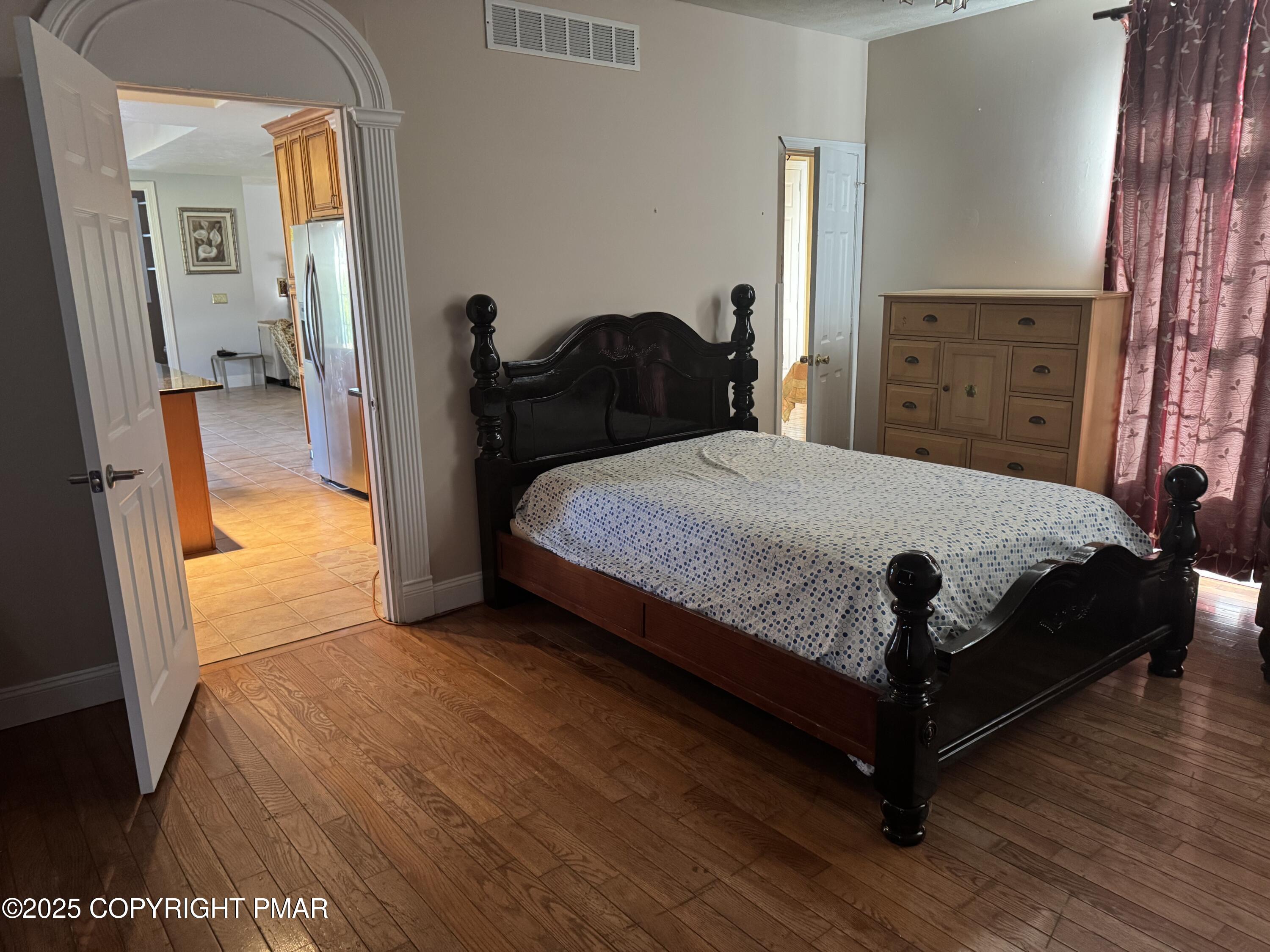 369 Bossardsville Road Stroudsburg, PA 18360 - Photo 11 of 17 a bedroom with a bed and wooden floor