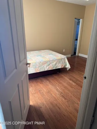 a bedroom with a bed and a wooden floor