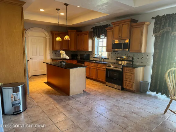 a kitchen with stainless steel appliances granite countertop a stove a sink and a refrigerator