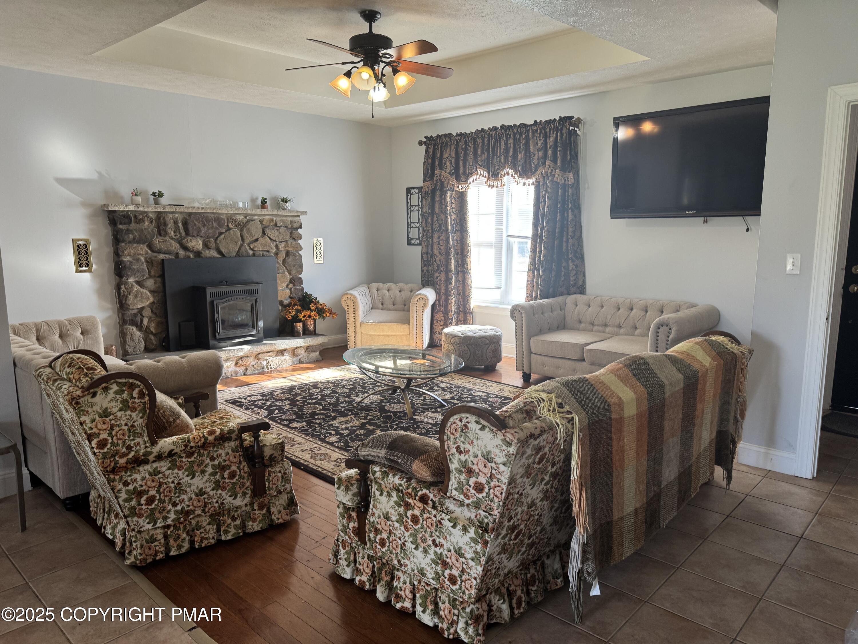 369 Bossardsville Road Stroudsburg, PA 18360 - Photo 7 of 17 a living room with furniture a flat screen tv and a fireplace