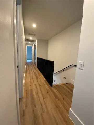 a kitchen with stainless steel appliances wooden floor and a refrigerator