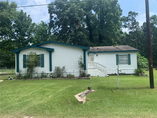 a view of a house with a yard and sitting area