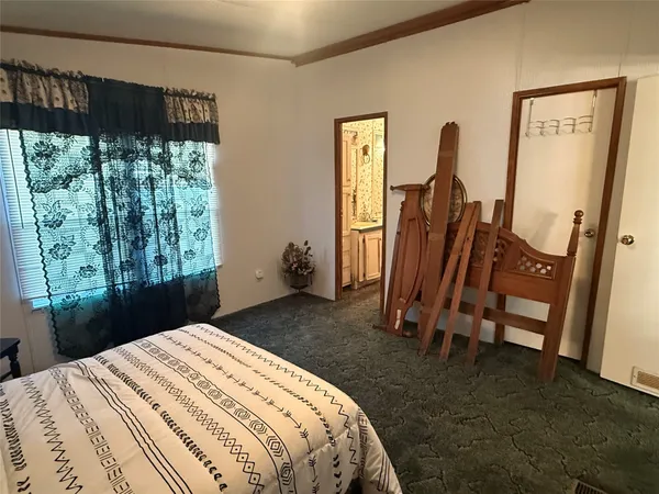 a bedroom with a bed a mirror and a large window