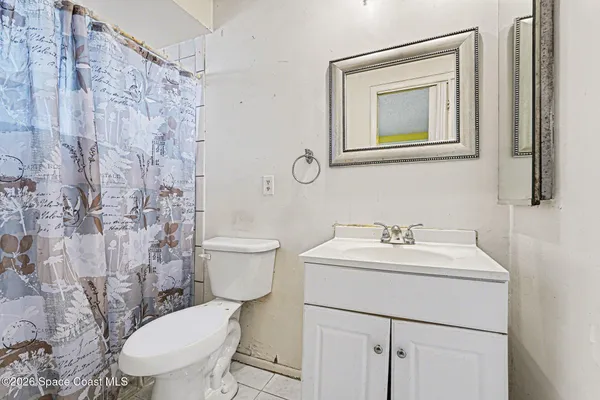 a bathroom with a toilet sink vanity and mirror