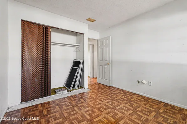 a view of a room with wooden floor and a bathroom
