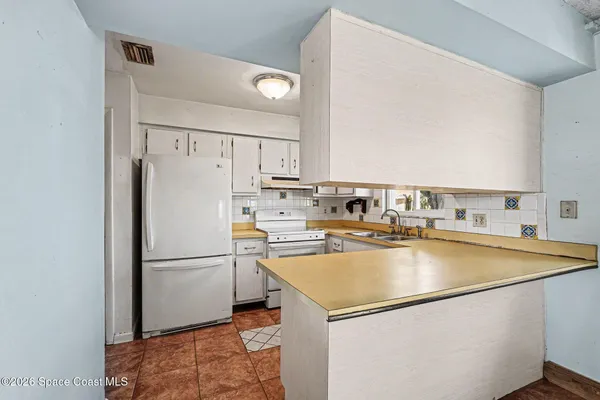 a kitchen with a refrigerator a stove and a sink