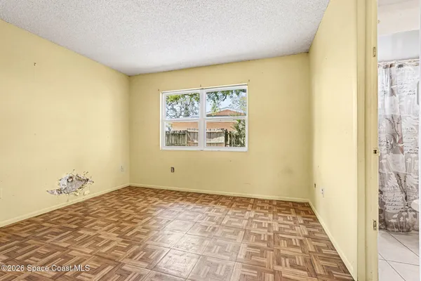 a view of a room with wooden floor and a window