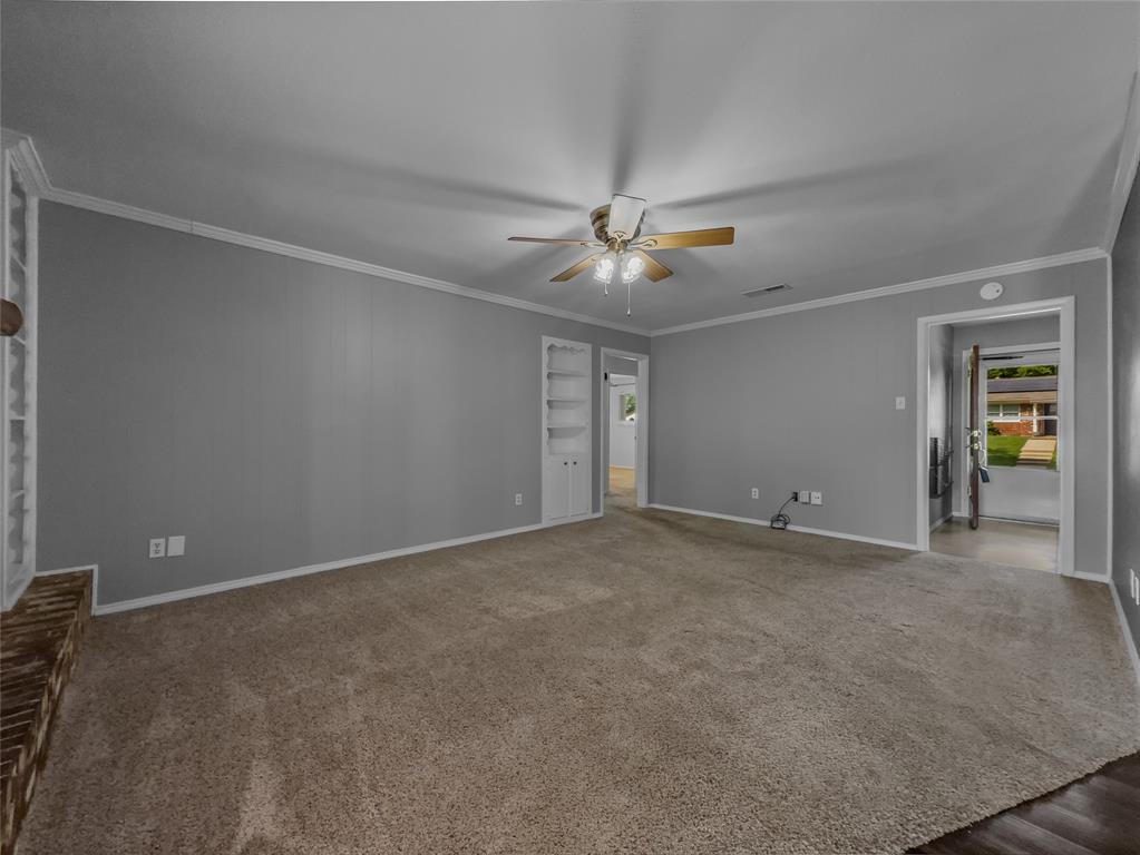 220 Cooper Drive Hurst, TX 76053 - Photo 4 of 27 an empty room with chandelier fan and windows