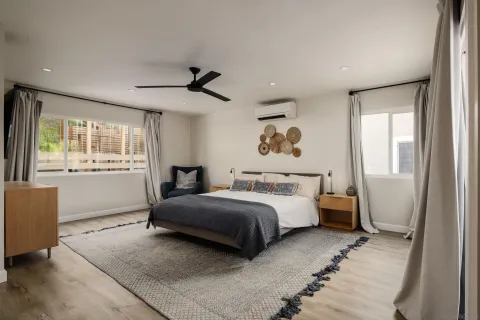 a spacious bedroom with a bed and a large mirror
